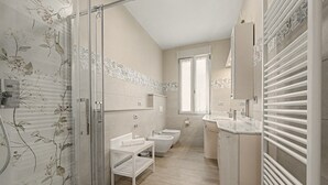 A modern bathroom with a shower, toilet, and sink.
