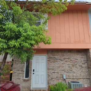 A two-story building with a brick facade and a white door. - Pet-Friendly Townhome w/ Fire Pit, 5mins to Beach (Fort Walton Beach)