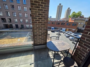 Ein Balkon mit Blick auf einen Parkplatz und Gebäude.
