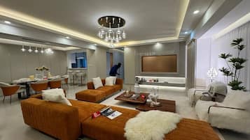 Una sala moderna con un sofá modular, una mesa de centro y un televisor.