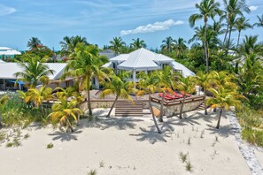 Un resort con diversi edifici, palme e una spiaggia sabbiosa.
