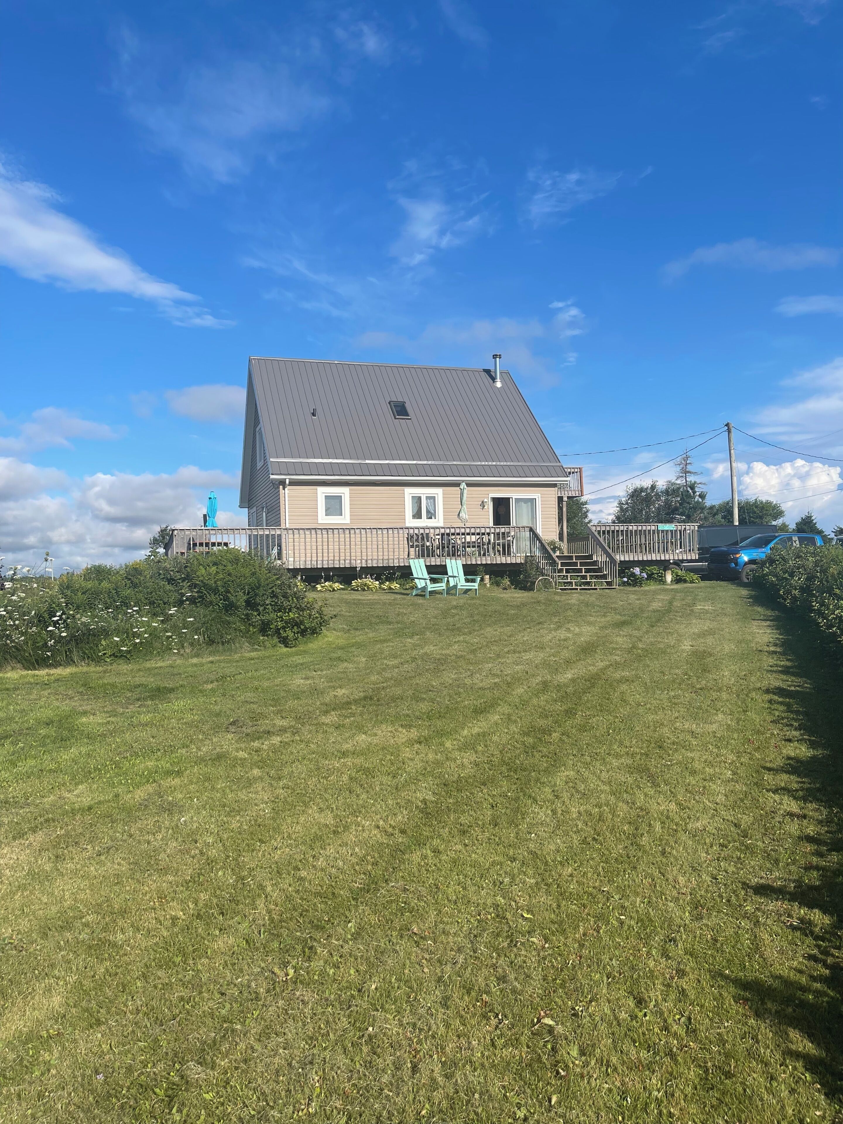 A house with a sloped roof, a porch, and a well-maintained lawn.