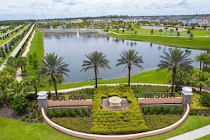 Resort com um elemento central de água, palmeiras e gramados bem cuidados.
