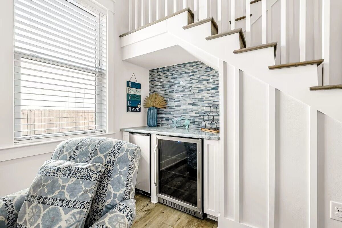 A modern kitchen with a built-in refrigerator, a small countertop, and a window with blinds.