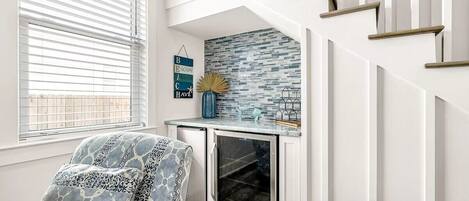 A modern kitchen with a built-in refrigerator, a small countertop, and a window with blinds.