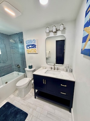 Un baño moderno con bañera, inodoro y tocador.