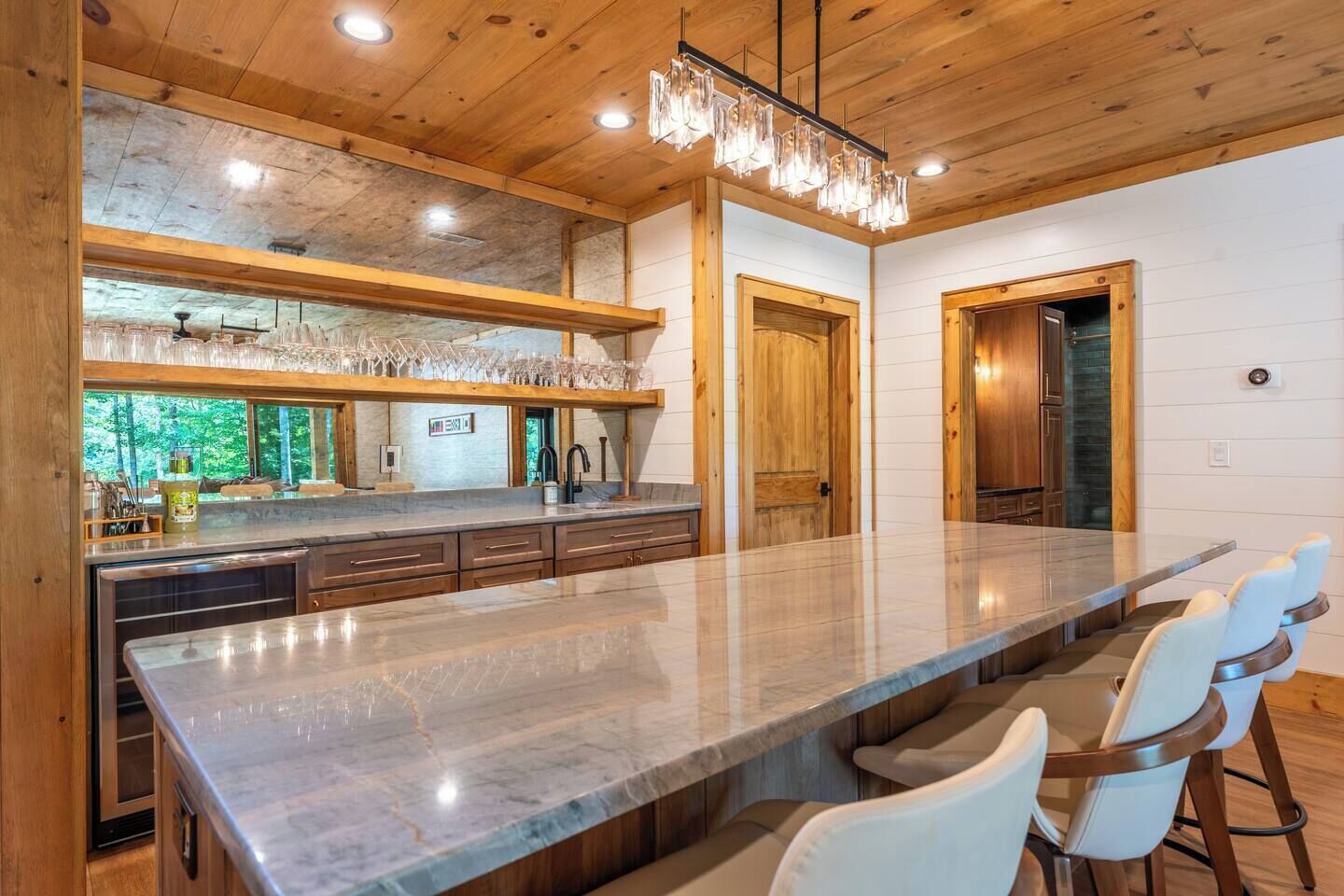 A spacious kitchen with a large island, wooden cabinetry, and a view of the outdoors.