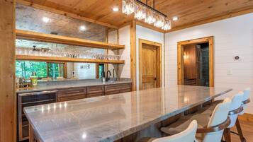 A spacious kitchen with a large island, wooden cabinetry, and a view of the outdoors.