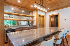 Una cocina amplia con una isla grande, armarios de madera y vistas al exterior.