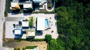 Vue aérienne d’une propriété comprenant plusieurs bâtiments, une piscine et de nombreux espaces verts.