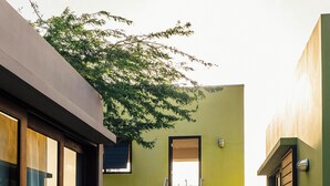 Un bâtiment moderne avec un escalier menant à l’entrée du deuxième étage, une porte vitrée sur la gauche et un sol en béton.