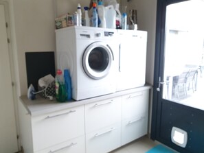 A laundry area with a washing machine, a drying rack, and various cleaning supplies. - Holiday Home 'Welcome' with Terraces, Private Garden and Wi-Fi (Le Relecq-Kerhuon)
