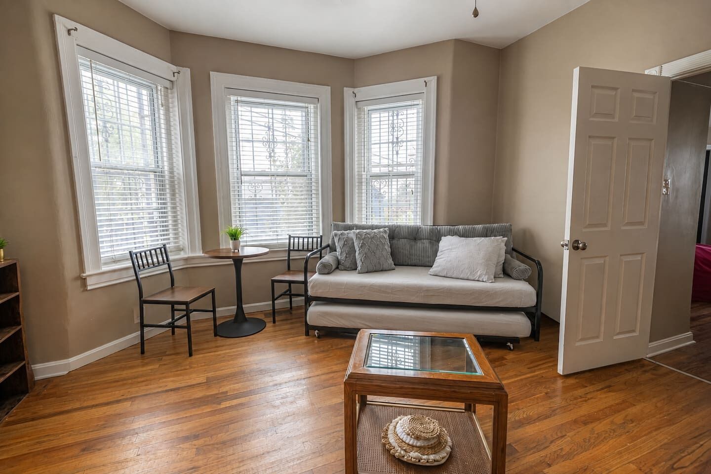 A living room with a sofa, chairs, a coffee table, and a door.