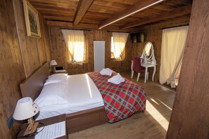 Ein Zimmer in einer Holzhütte mit einem Bett, einem Schreibtisch und einem Stuhl.
