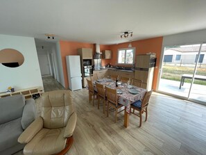 Una cocina moderna con comedor, sofá y vistas al exterior.