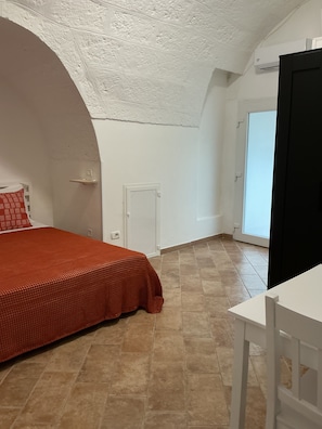 Una camera da letto con un letto grande, una porta bianca e una finestra.