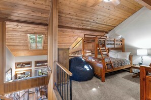 A bedroom with a bunk bed, a bean bag, a desk with a lamp, and a view of the outdoors through a window. - 2BR + Loft Condo | Shared Pool & Shuttle Access (Mammoth Lakes)