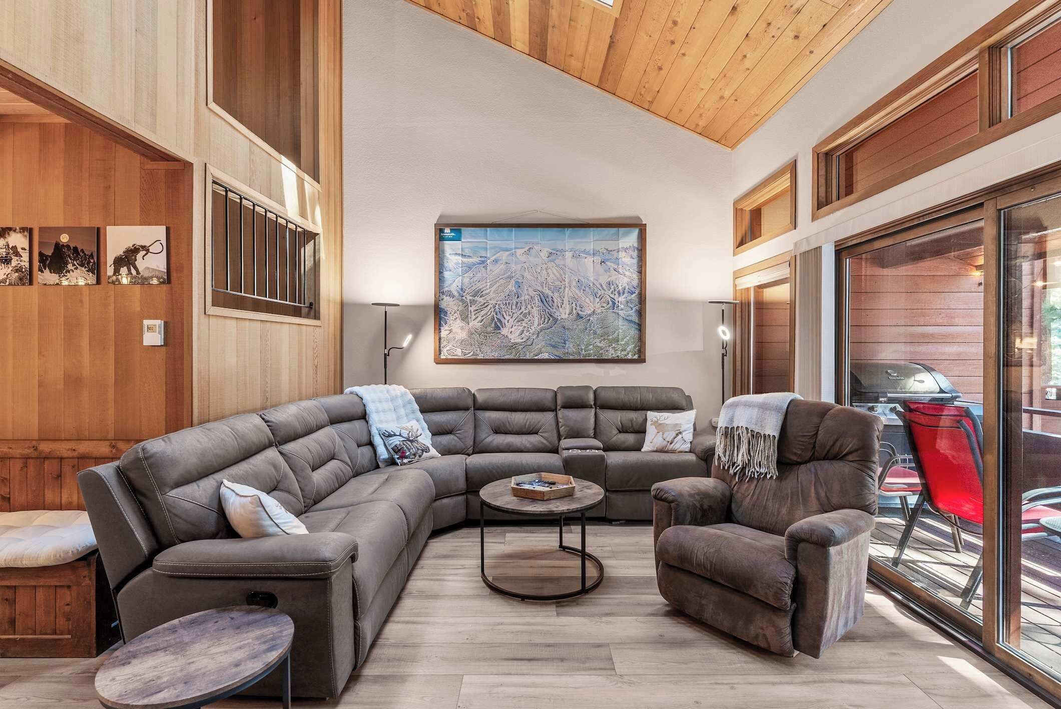 A modern living room with a sectional sofa, a round coffee table, and a large window with a view of the outdoors.