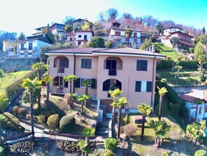 A multi-story building with a symmetrical facade, multiple windows, and a central entrance. - 180° View of Lake Maggiore and the Alps (Meina)