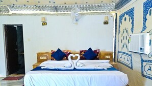 Ein Hotelzimmer mit einem Bett, einem Nachttisch, einer Wand-Klimaanlage und einer Zierte Decke.