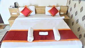 Ein Hotelzimmer mit einem Bett, zwei Kissen, einem Nachttisch und einer Wand mit Muster.