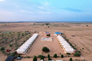Un espacio amplio y abierto con varias estructuras cubiertas dispuestas en un patio central.