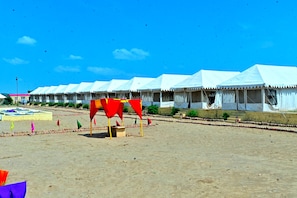 A row of white tents with a sandy ground in front. - Desert Vibe Resort (Jaisalmer)