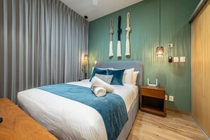 A modern bedroom with a large bed, a nightstand, and a wall-mounted lamp. - Modern Studio | Gym + Rooftop Pool, Free Parking (Playa del Carmen)