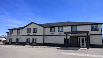 A two-story building with a flat roof, large windows, and a covered entrance.