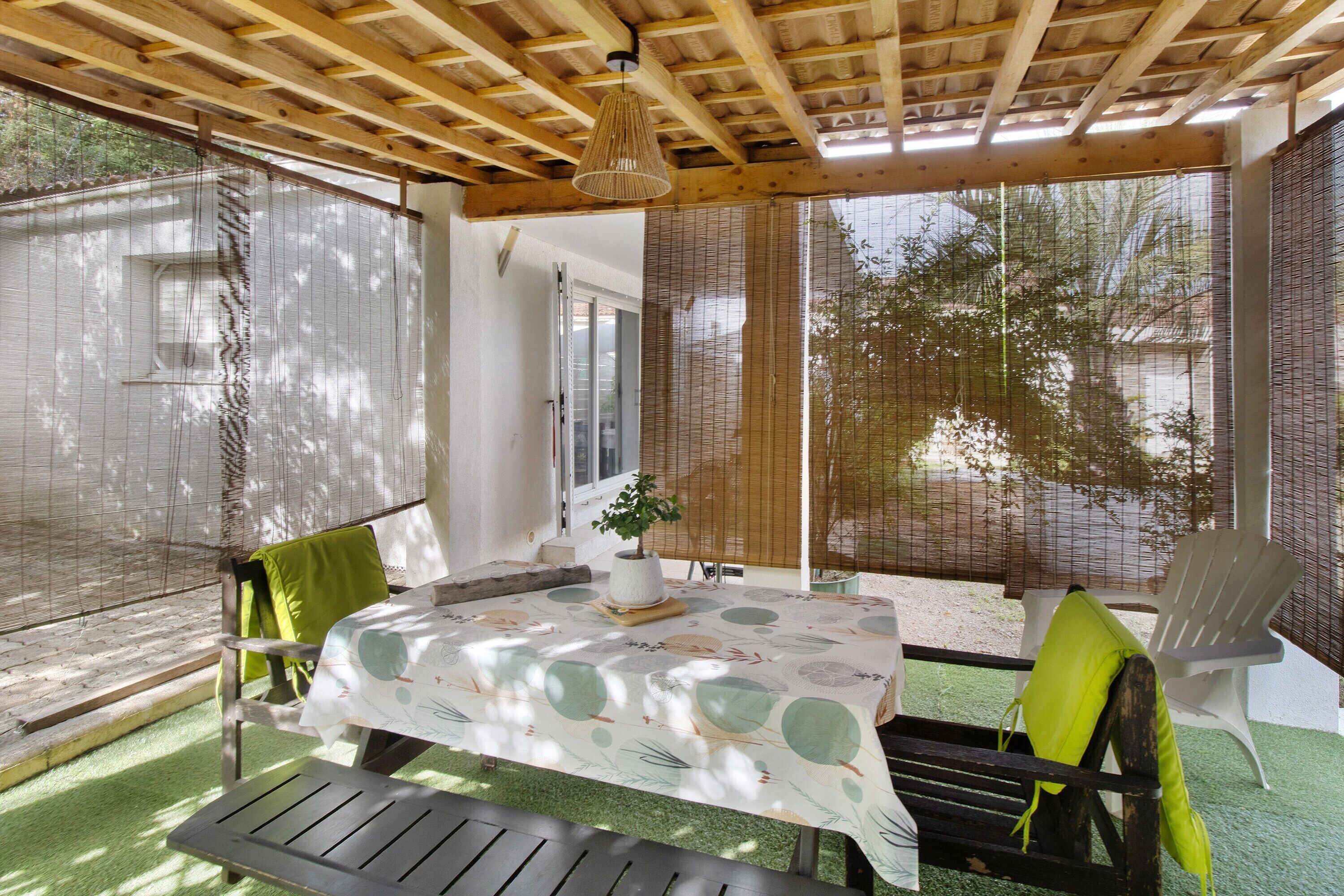 Un patio couvert comprenant une table, des chaises et un banc.