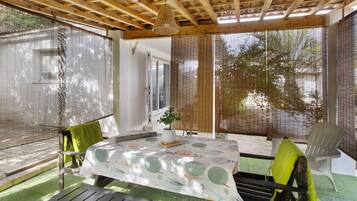 Un patio couvert comprenant une table, des chaises et un banc.