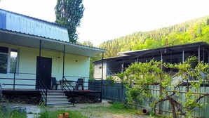 A two-story building with a covered porch, a fenced yard, and a dog in the foreground.