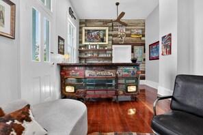 Une pièce avec une radio ancienne, des lambris en bois et un fauteuil en cuir noir.