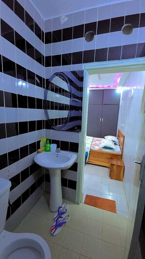 Ein Badezimmer mit Toilette, Waschbecken und Duschbereich.