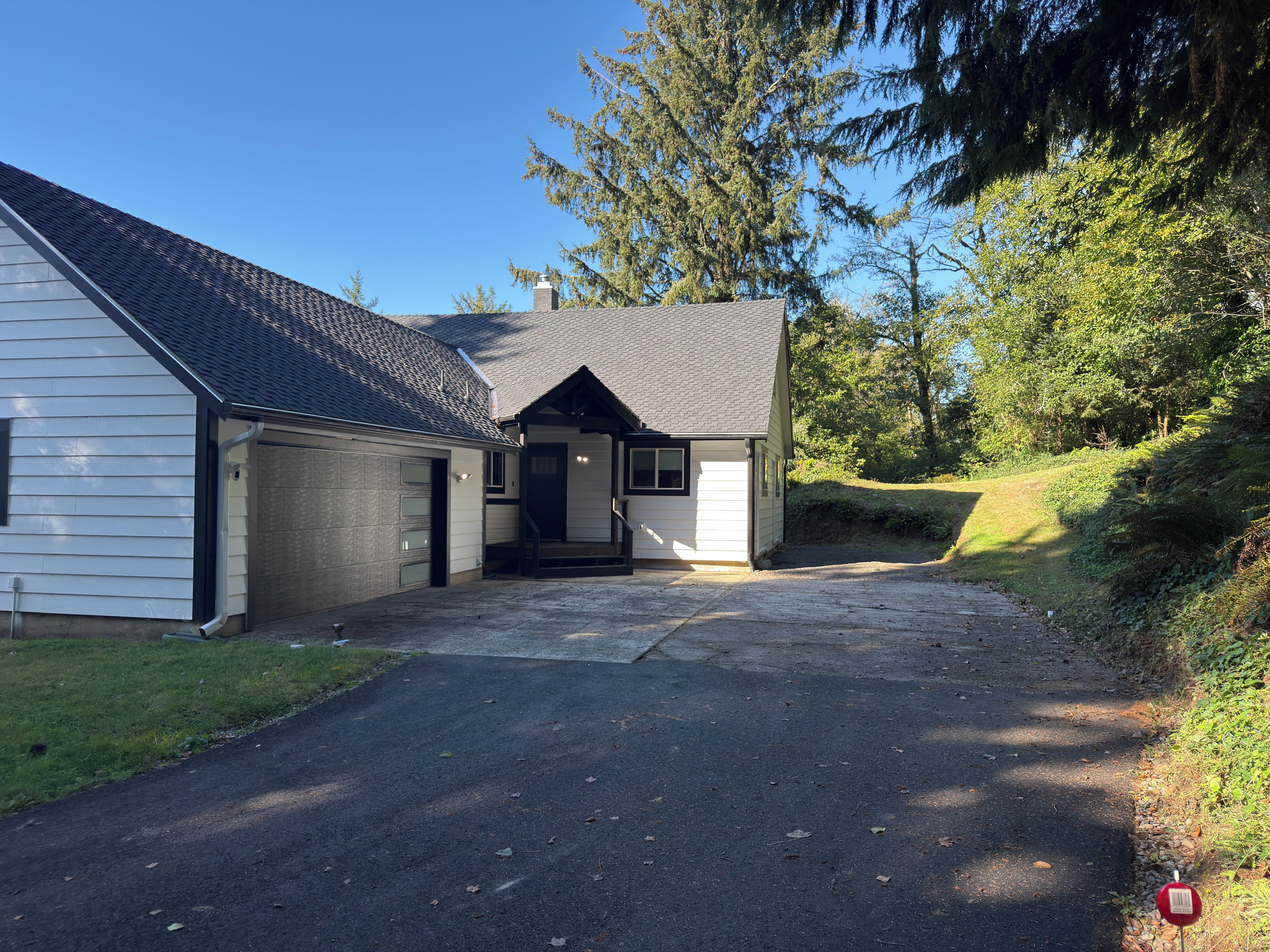 A two-story house with a garage, a covered porch, and a driveway leading to the entrance.