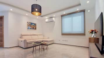 Una sala moderna con un sofá, una mesa de centro y un cuadro en la pared.