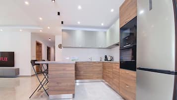 Una cocina moderna con armarios de madera, un refrigerador de acero inoxidable y una cafetera.