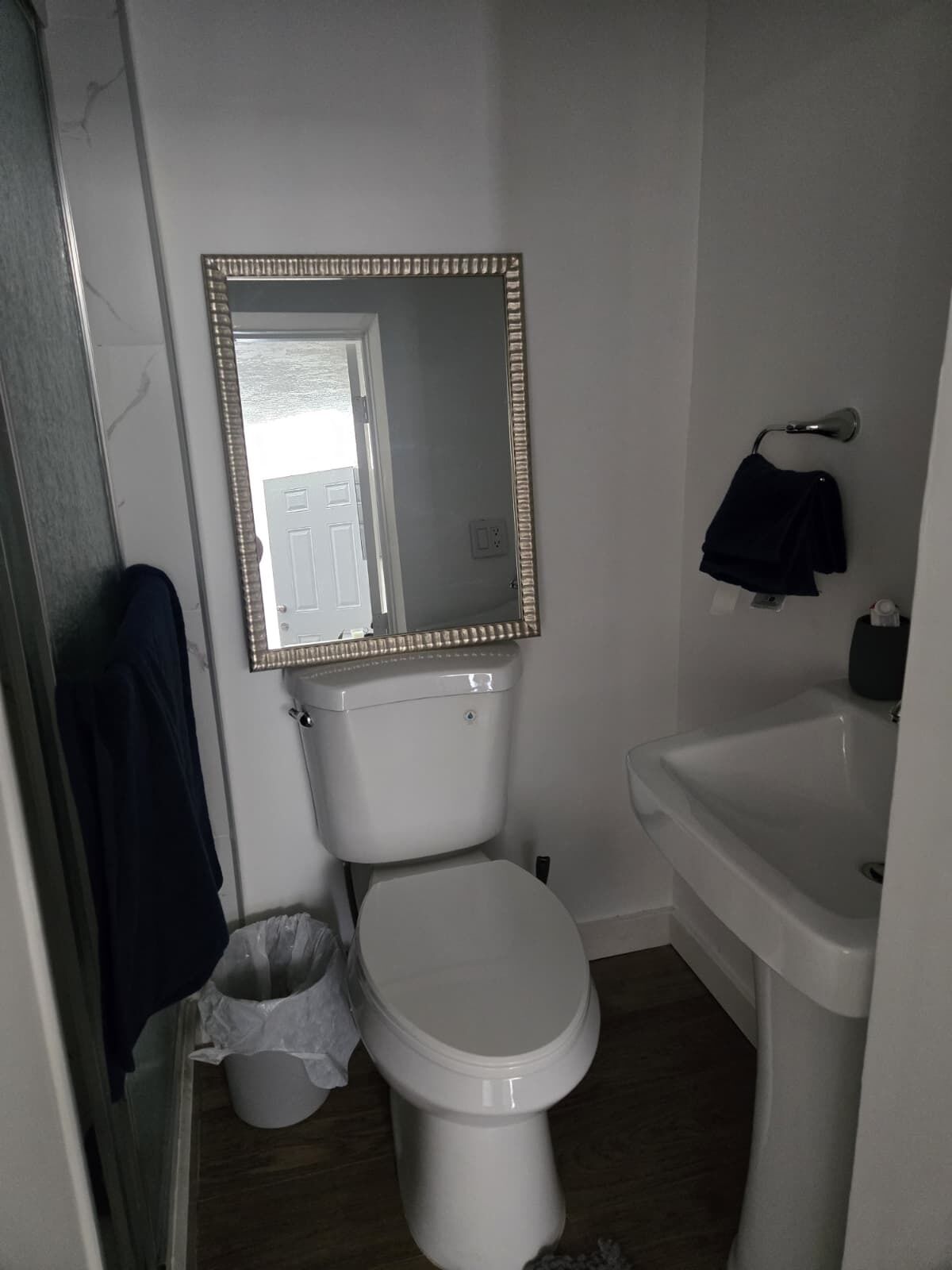 Ein kleines Badezimmer mit Toilette, Waschbecken und Spiegel.