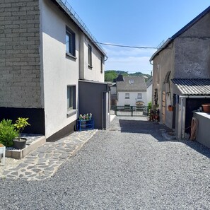 A narrow alleyway with cobblestone pavement, flanked by buildings with a mix of brick and plaster exteriors.