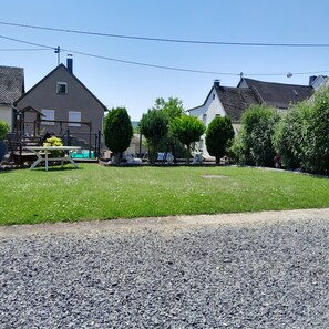 Ein Wohngebiet mit Häusern, einem Spielplatz und einem Kiesweg.