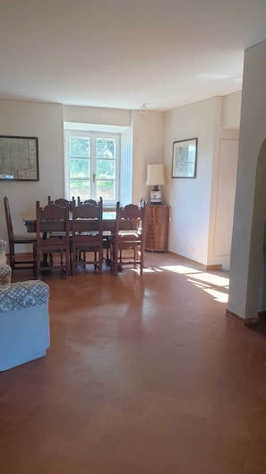 A dining area with a wooden table and chairs, a lamp, and a cabinet. - A charming historic farmhouse, 10 minutes from Orvieto, with a garden and private pool, (Umbria)