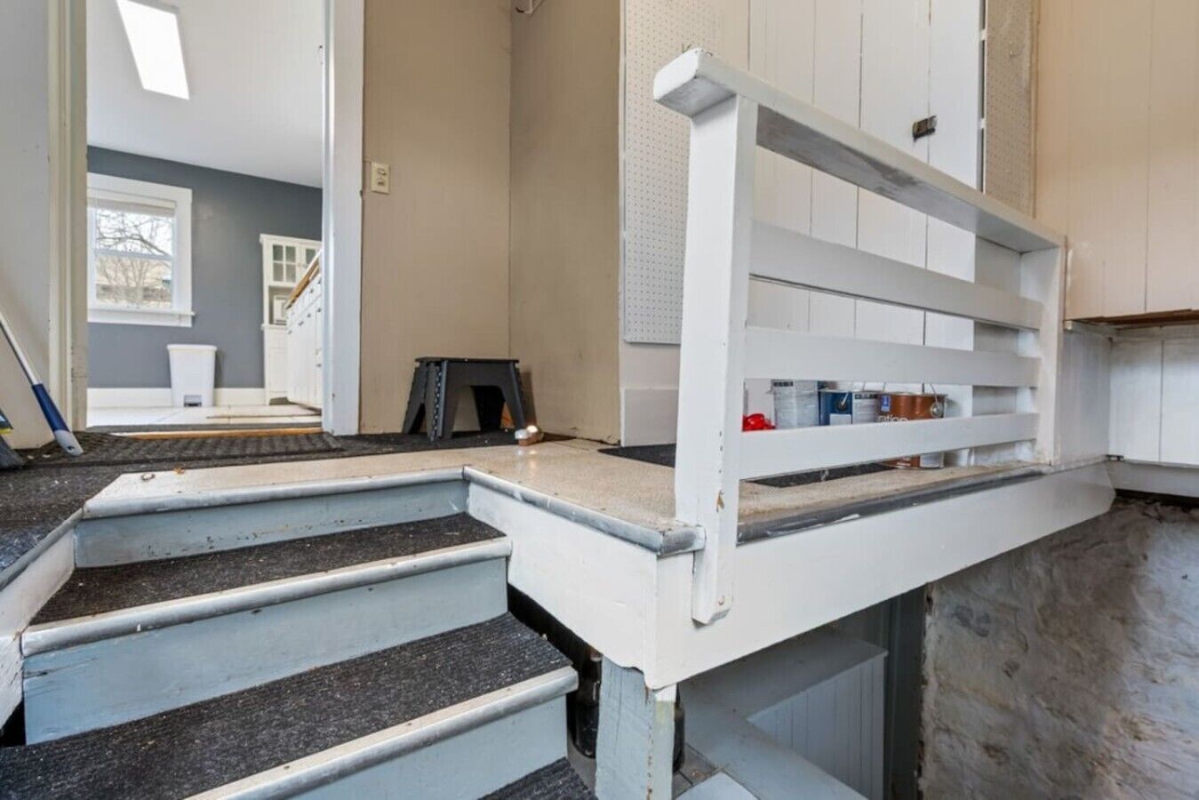 Un escalier menant à une pièce dotée d’une rambarde blanche et d’une fenêtre.