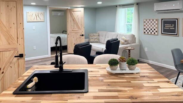A modern kitchen with a built-in dishwasher, wooden countertop, and a sink with a faucet.