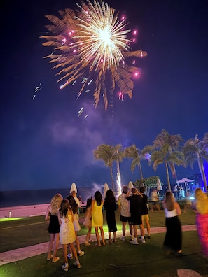 A group of people gathered on a beach at night, watching fireworks. - Beachfront, family friendly, 2-bedroom + loft villa at The Palms, Playa Flamingo (Playa Flamingo)