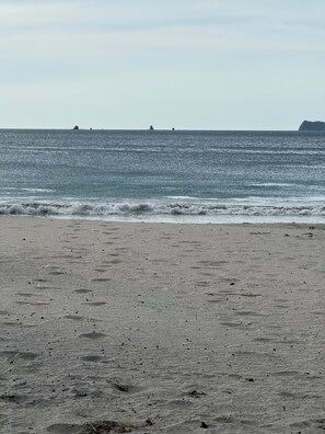 En strand med en sandstrand och ett lugnt hav.