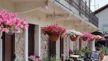 Ein Gebäude mit Balkon, Außenbereich und hängenden Blumenkörben.