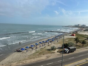 A beach with umbrellas and a road parallel to the shore. - APARTMENT WITH A SEA VIEW (Cartagena de Indias)