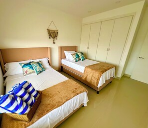 A hotel room with two beds, a wardrobe, and a hanging decoration. - APARTMENT WITH A SEA VIEW (Cartagena de Indias)