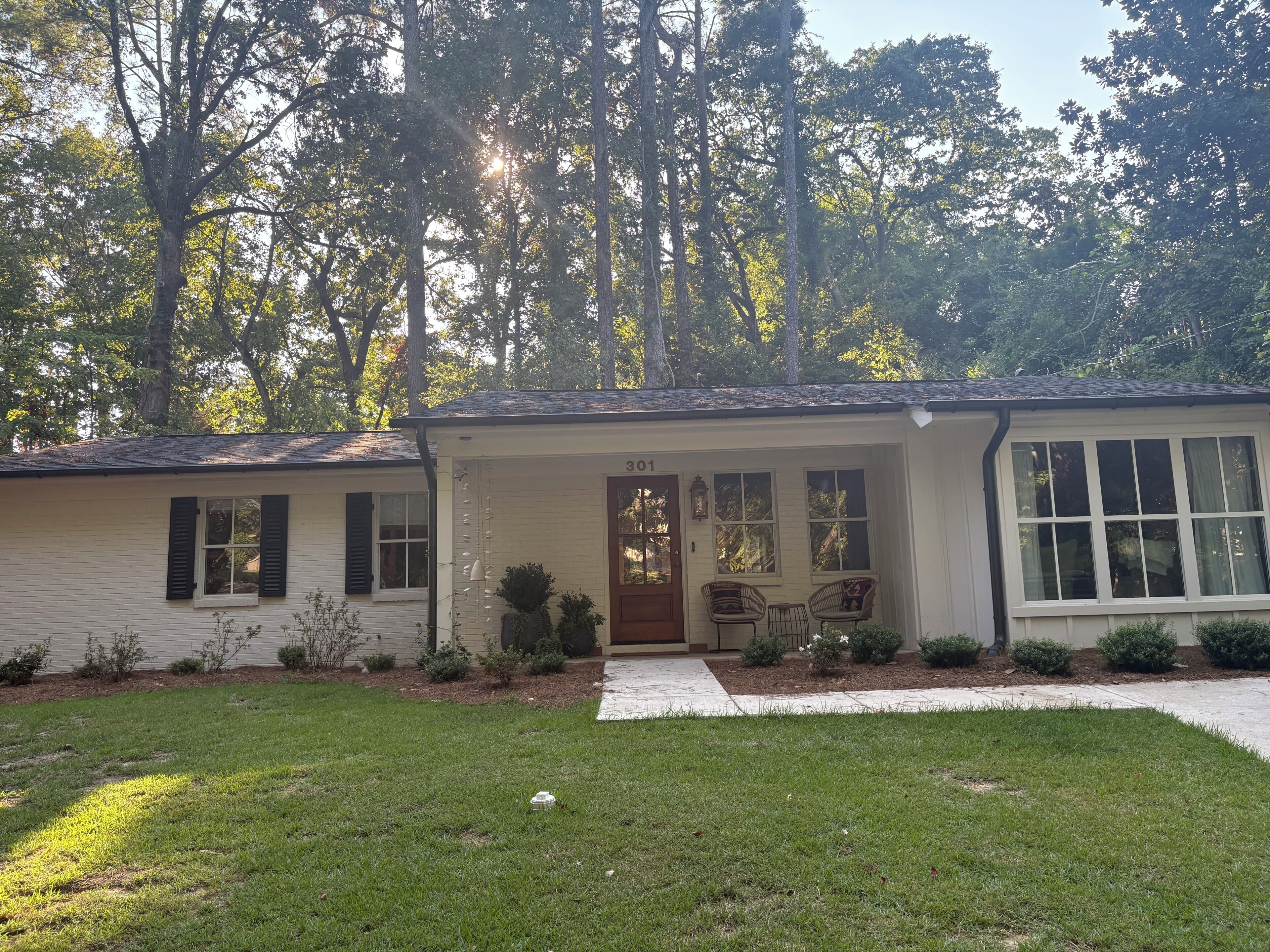 Een gelijkvloers huis met een veranda, een brievenbus en het nummer 301 op de deur.