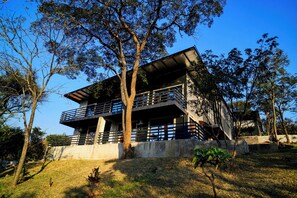 A modern two-story building with a balcony, surrounded by trees. - Sunset Villa at Forest Hill House (LUSAKA)